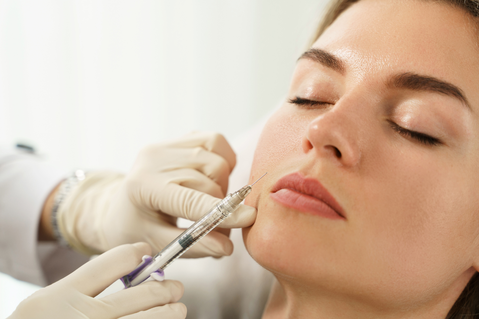 Woman receiving dermal filler injection on the face