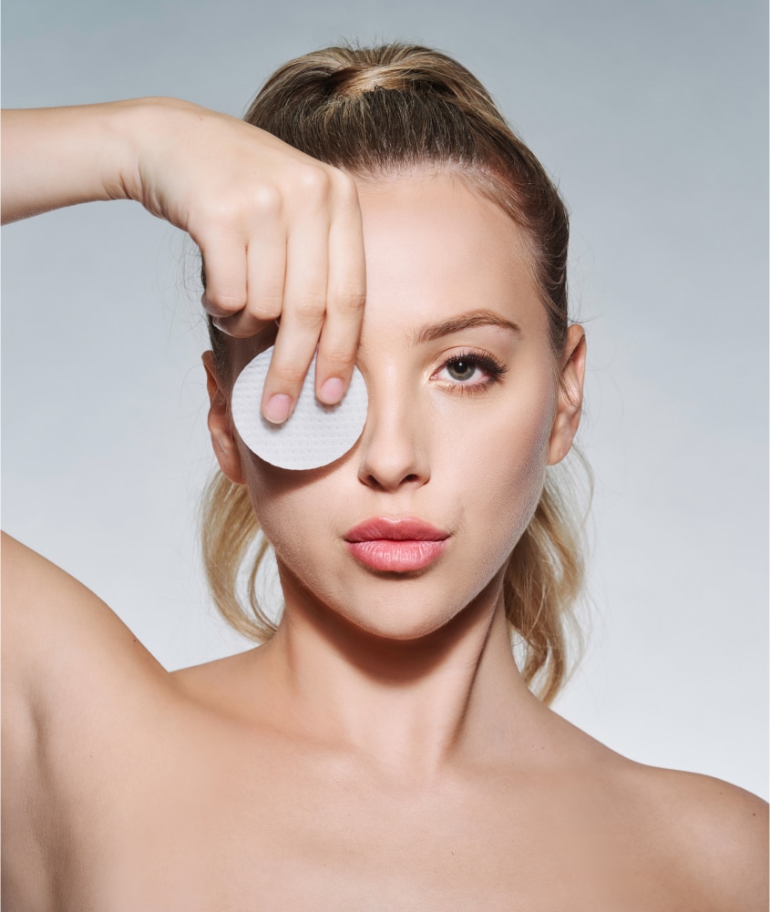 Blonde client holding a ZO® Oil Control Pad, representing medical-grade skincare services available at Allure Aesthetics in King of Prussia and the greater Philadelphia area