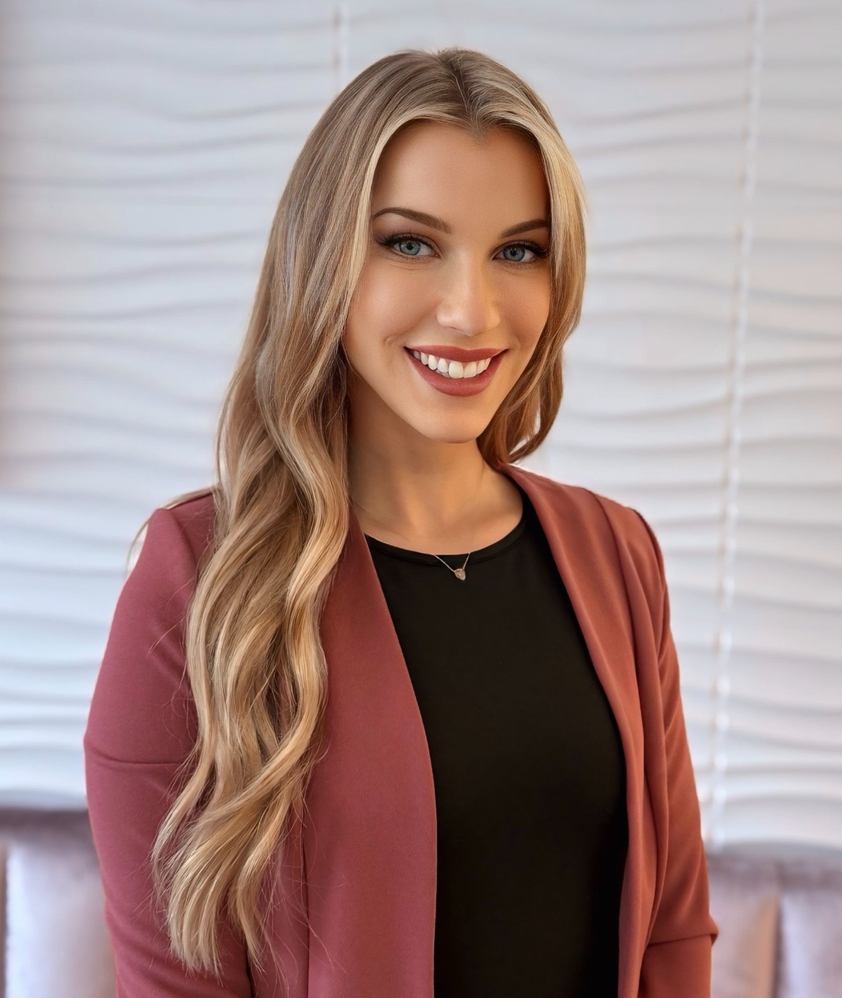 Lauren Komorowski, Director of Operations at Allure Aesthetics, smiling warmly in an elegant, softly lit setting.