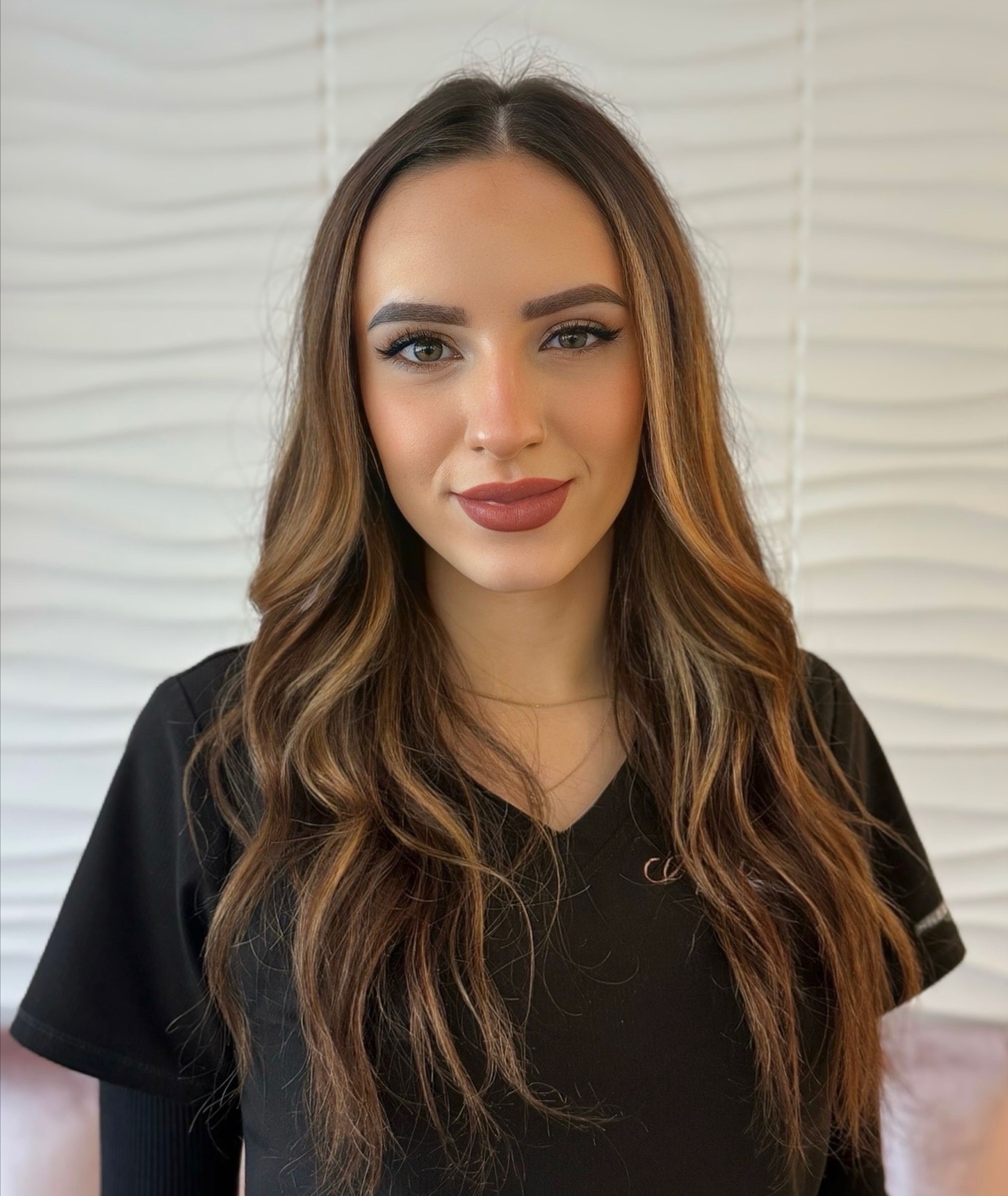 Michelle Gibson, Medical Assistant at Allure Aesthetics, smiling in a refined clinical environment.