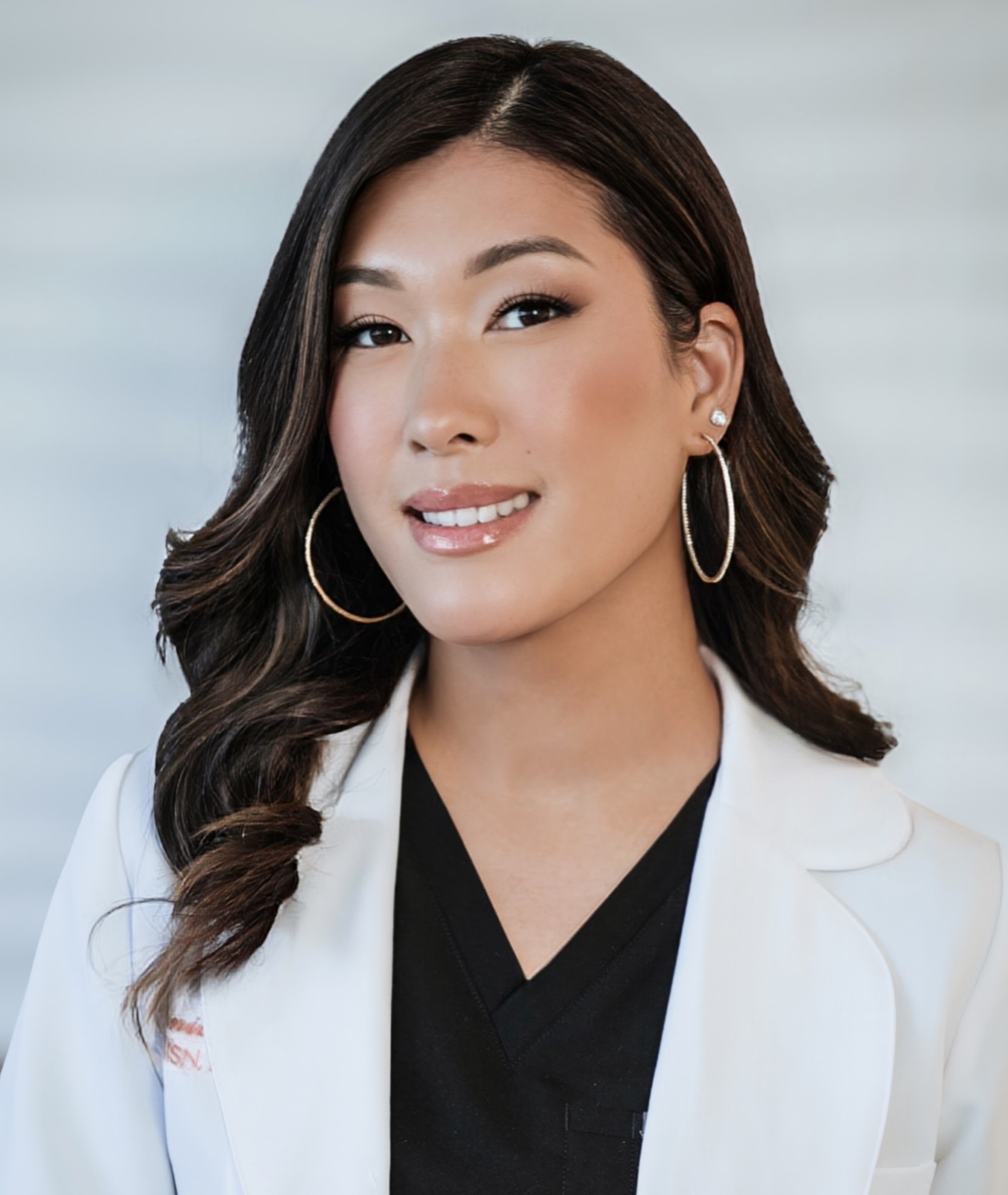 Annie Zavitsanos, CRNP, seated in a softly lit space at Allure Aesthetics, wearing a warm expression that reflects her compassionate, client-centered care approach.