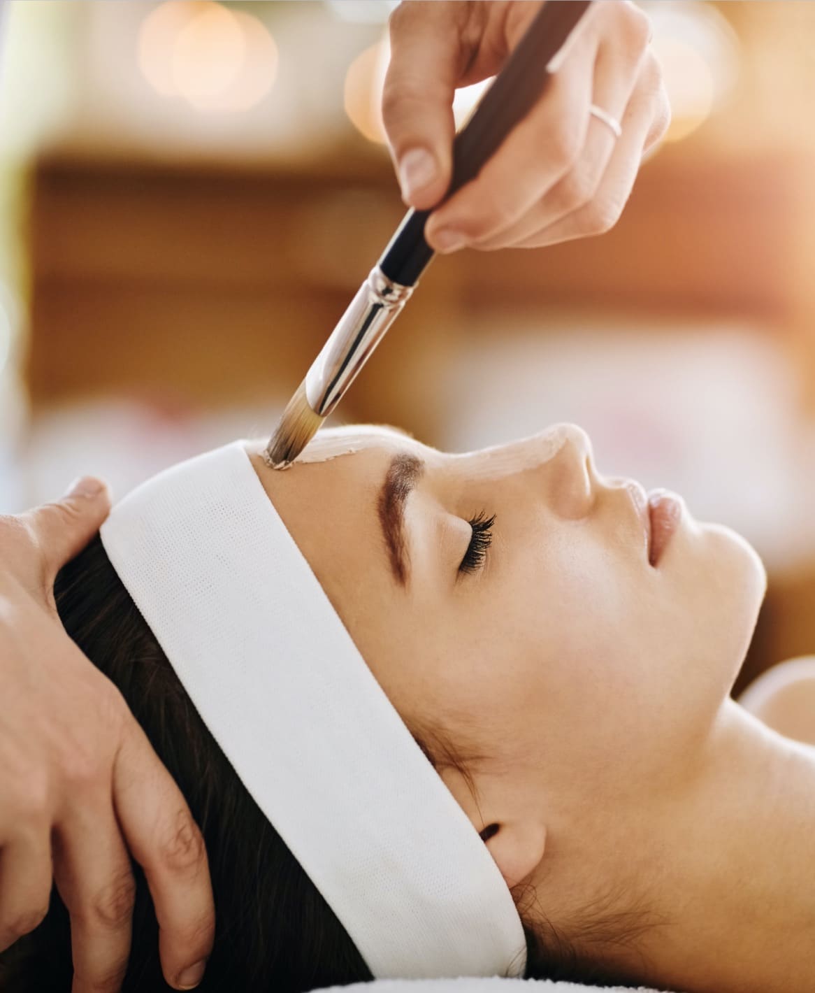 Woman lying down receiving a chemical peel treatment at Allure Aesthetics, designed to improve skin health.